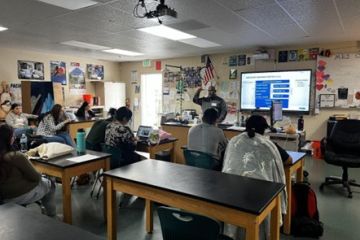 Amgen staff person speaking in front of students about his career