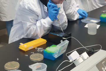 student using a pipette in the lab