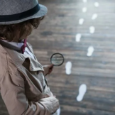 female detective looking at suspicious footprints