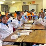 Student sin a science classroom waving to the camera