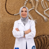 Woman in white lab coat facing the camera