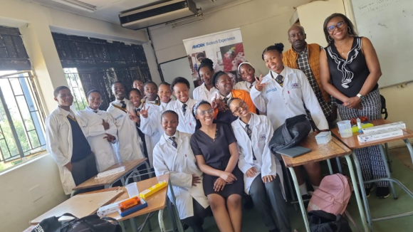 Group photo of students and their teacher in a South African high school classroom